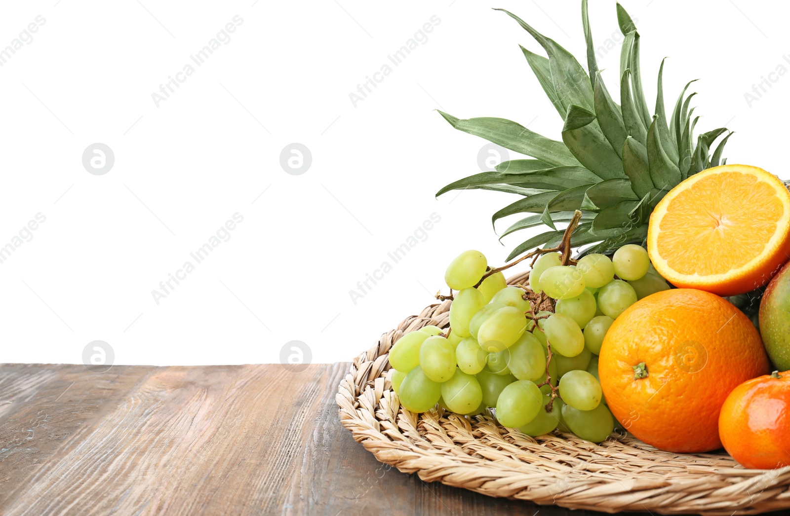 Photo of Wicker mat with fresh tropical fruits on wooden table