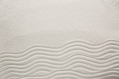 Photo of White sand with pattern as background, top view. Zen concept