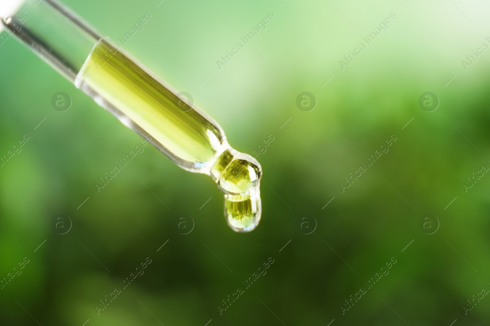 Photo of Pipette with essential oil on blurred background. Space for text