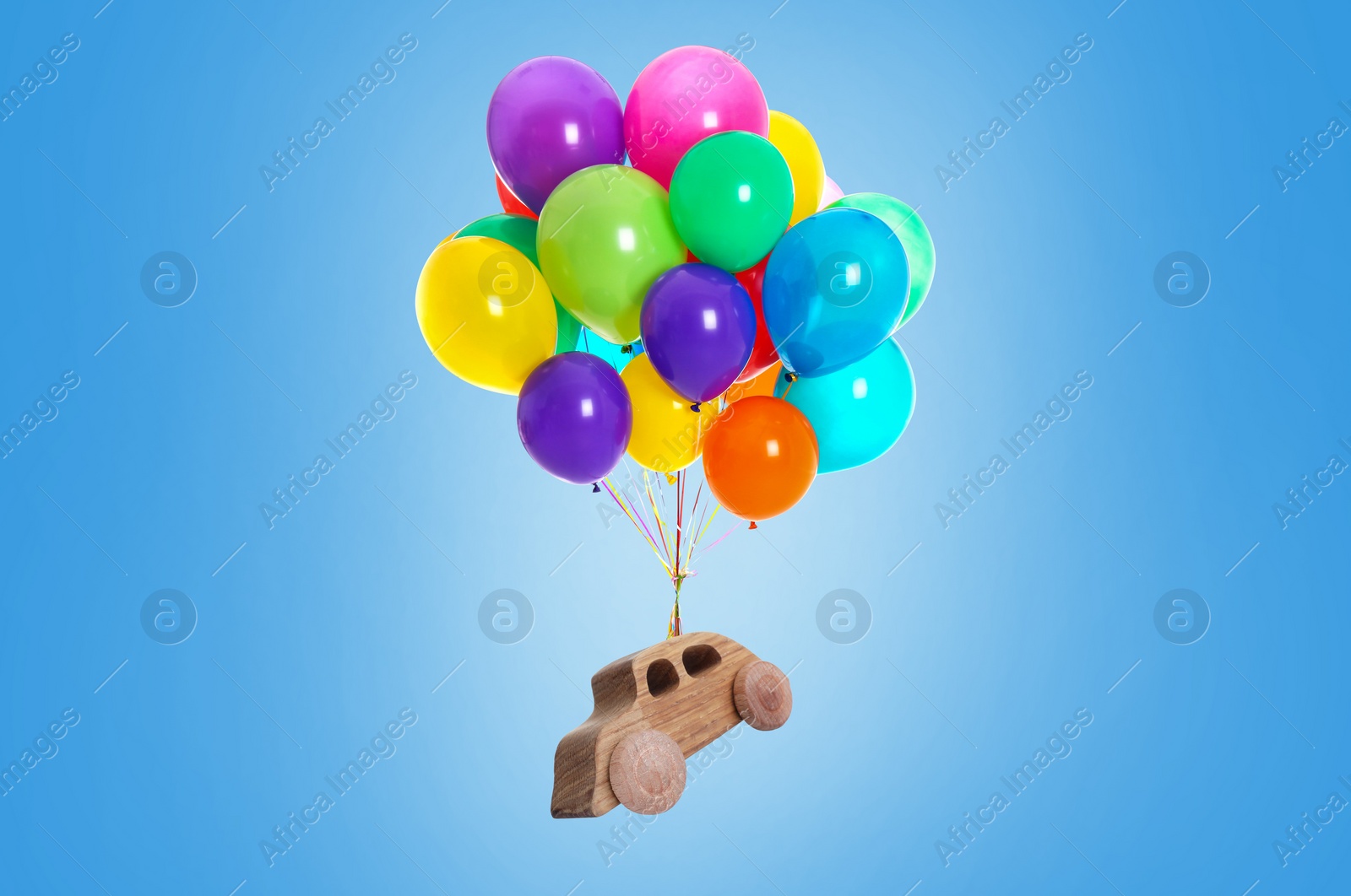 Image of Many balloons tied to wooden toy car flying on light blue background