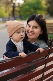Family portrait of happy mother and her baby on bench in park