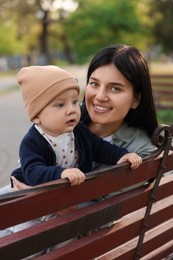 Photo of Family portrait of happy mother and her baby on bench in park