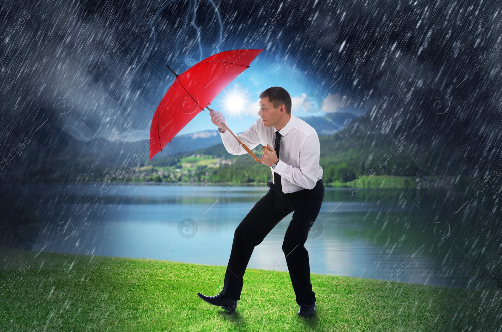 Image of Businessman with umbrella under heavy rain. Insurance concept