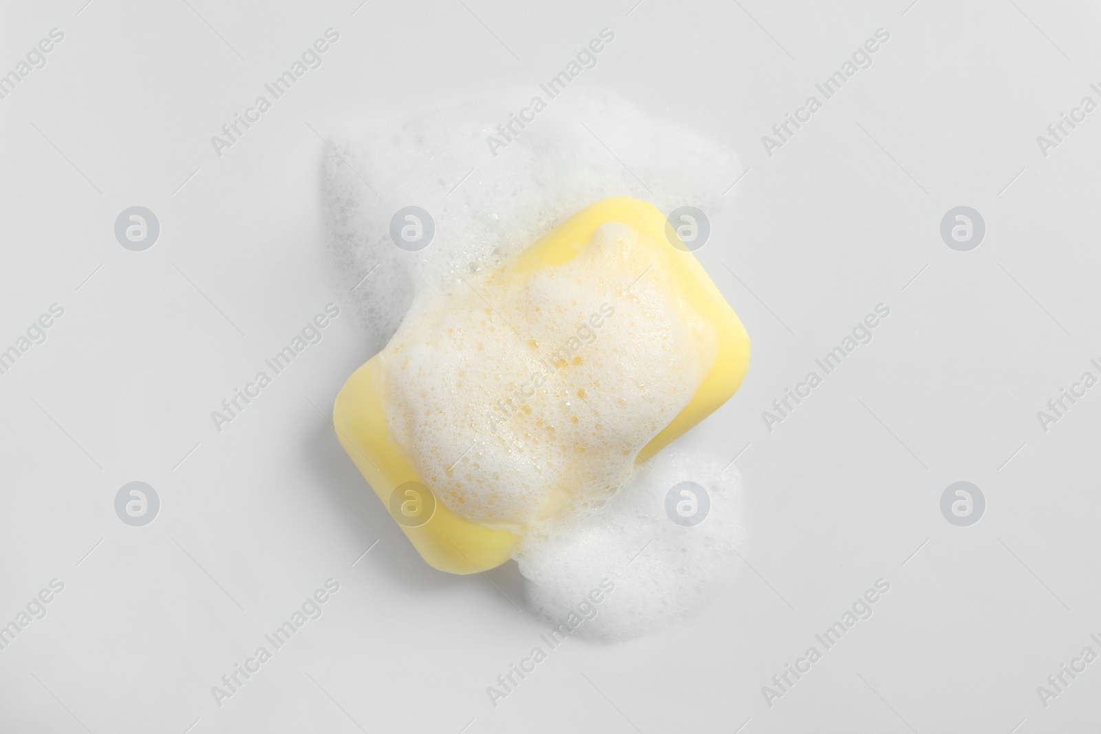 Photo of Soap and fluffy foam on white background, top view