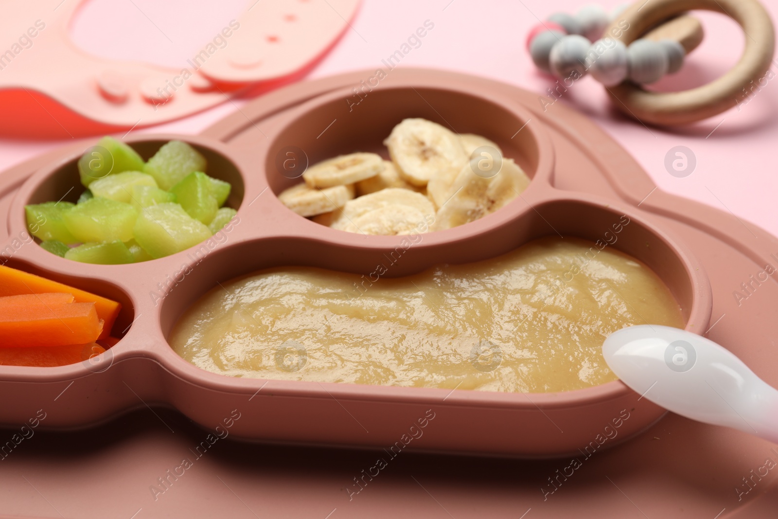 Photo of Healthy baby food. Section plate with delicious apple puree, vegetables and fruit on pink background, closeup