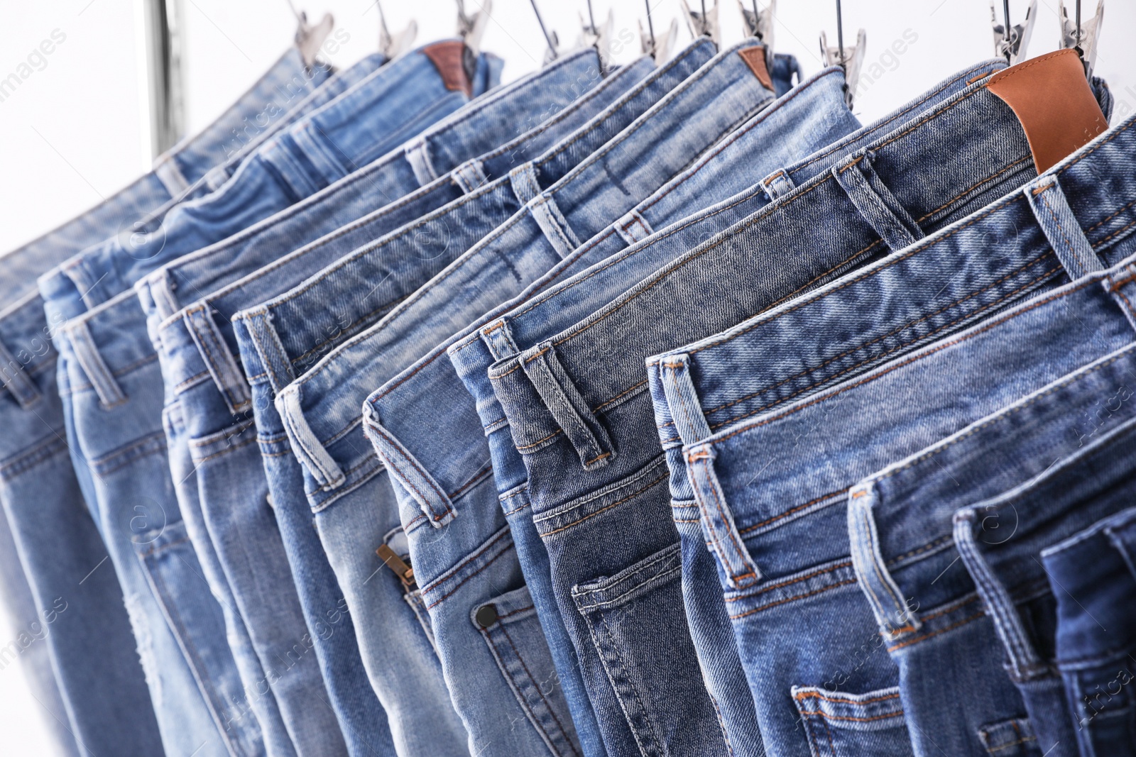 Photo of Closeup view of rack with different jeans