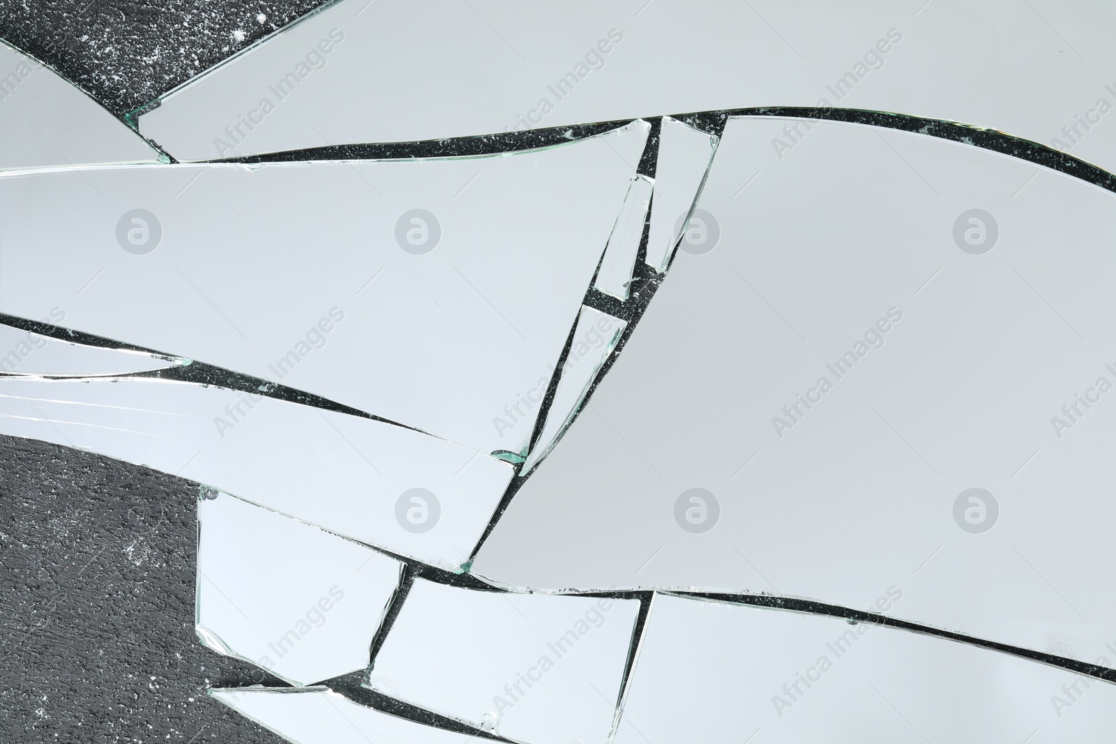 Photo of Shards of broken mirror on dark textured background, top view