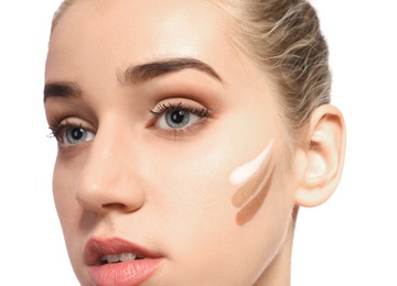 Photo of Young woman with different shades of skin foundation on her face against white background. Professional makeup