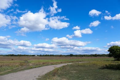 Photo of Picturesque view of pathway in field above cloudy sky