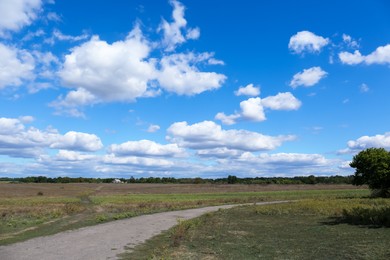 Picturesque view of pathway in field above cloudy sky