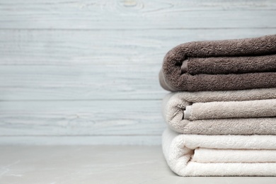 Photo of Stack of fresh towels on table. Space for text