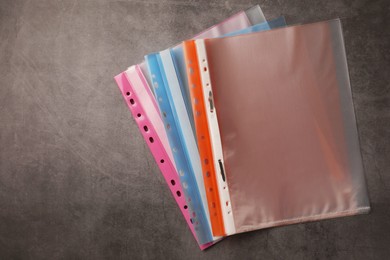 Photo of File folders with punched pockets on grey table, flat lay. Space for text