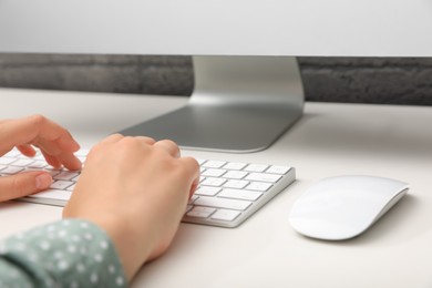 Photo of Woman working on computer at white table, closeup