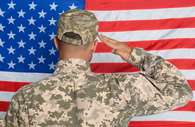 Photo of Soldier in uniform against United states of America flag, back view