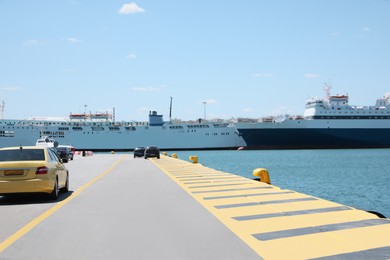 Photo of Picturesque view of port with modern boats and cars on sunny day