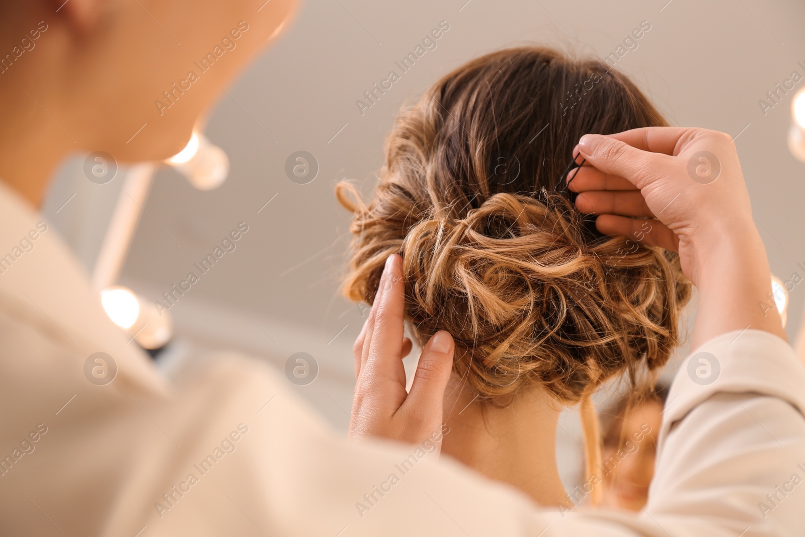 Photo of Stylist working with client in salon, making hairstyle