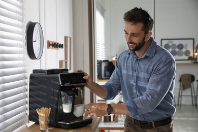 Photo of Man preparing fresh aromatic coffee with modern machine in office