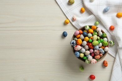 Photo of Ceramic bowl with delicious candies on white wooden table, flat lay and space for text. Cooking utensil