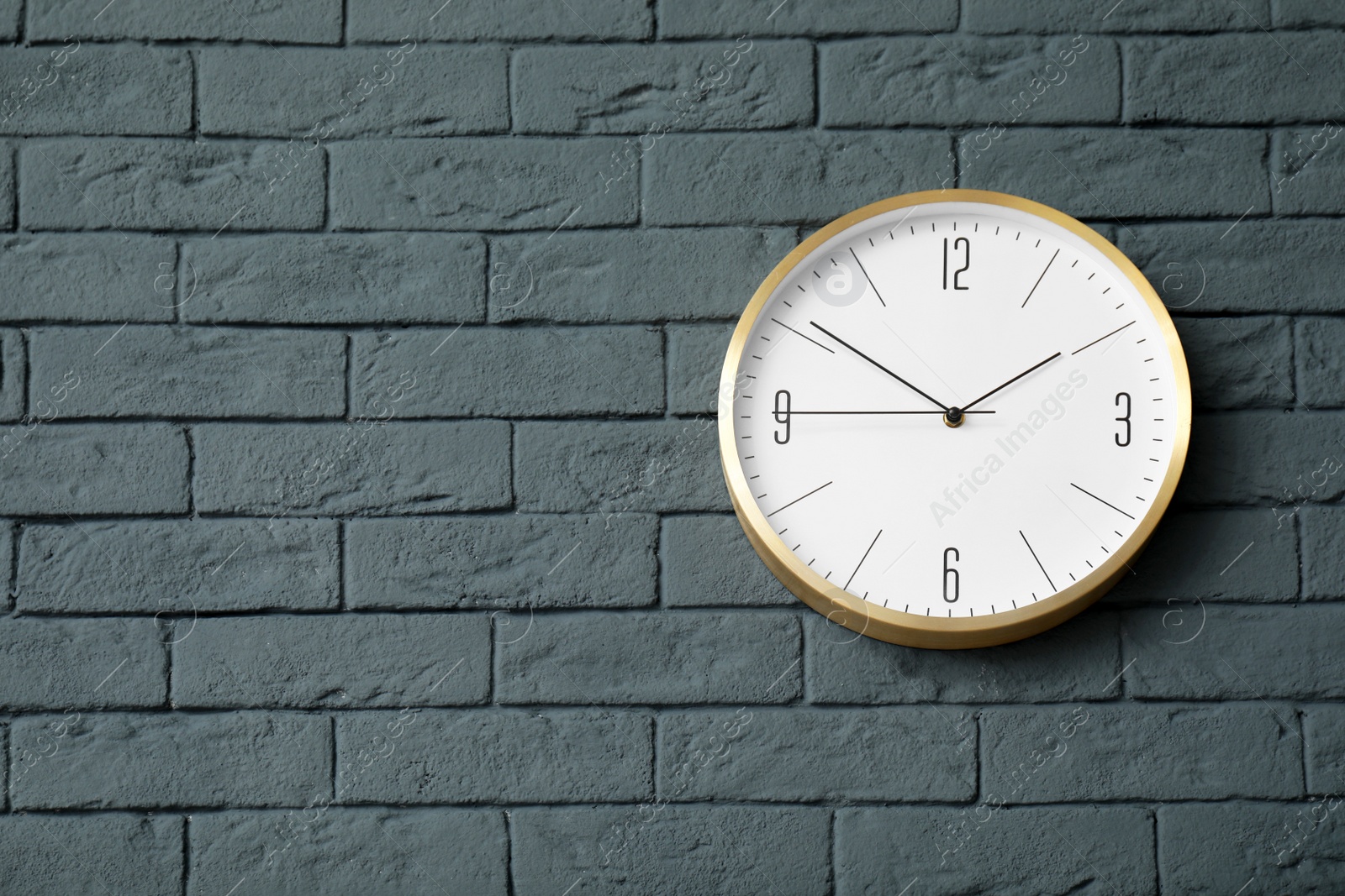 Photo of Modern clock on brick wall. Time concept