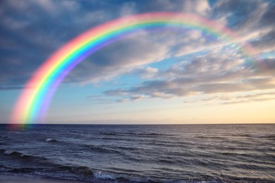 Image of Beautiful view of colorful rainbow in sky over sea