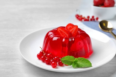 Photo of Delicious fresh red jelly with berries and mint on white table