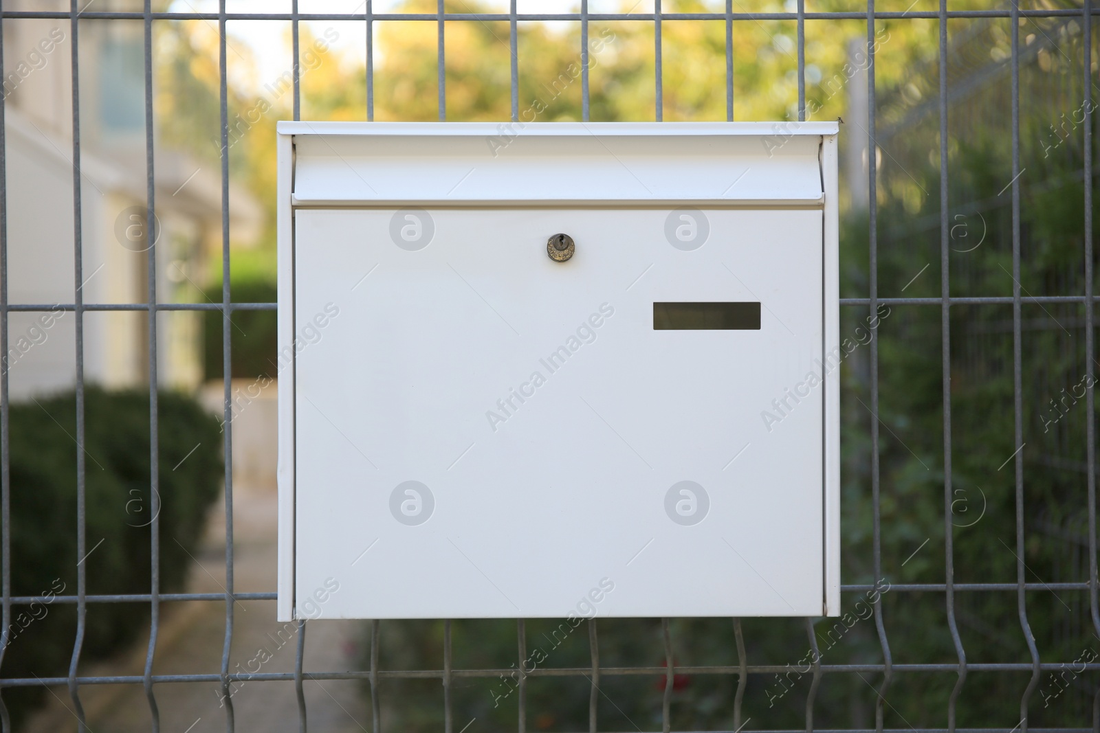 Photo of White metal letter box on fence outdoors