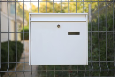 White metal letter box on fence outdoors