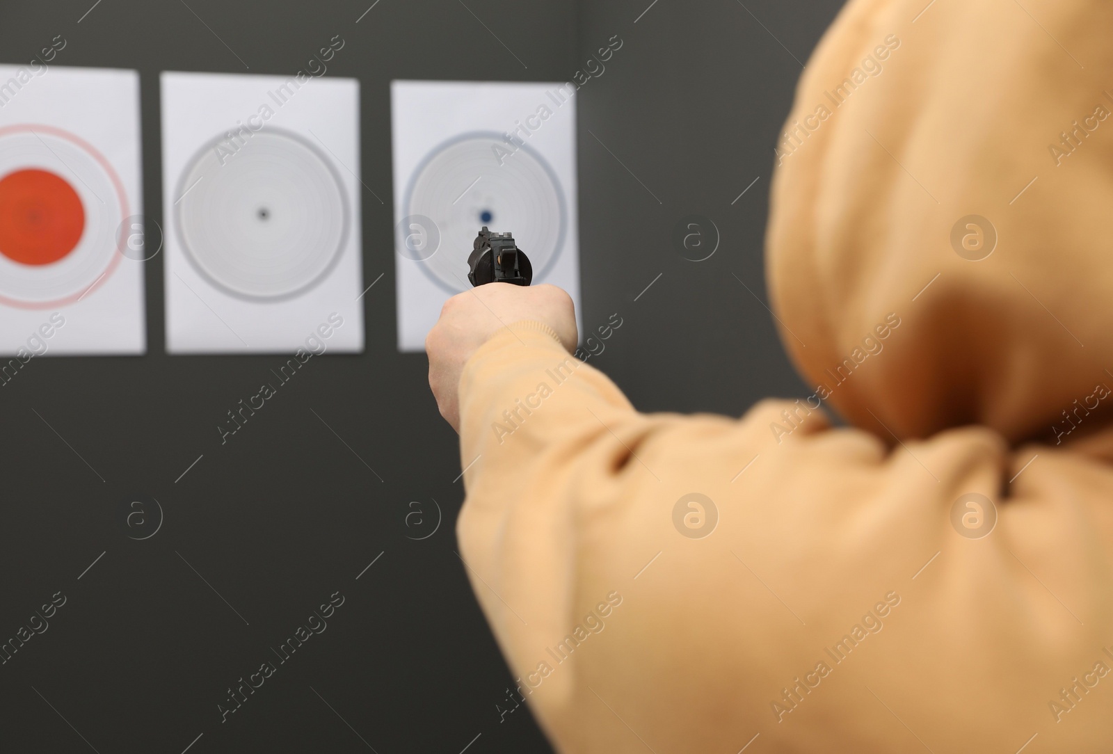 Photo of Man aiming at shooting target indoors, closeup