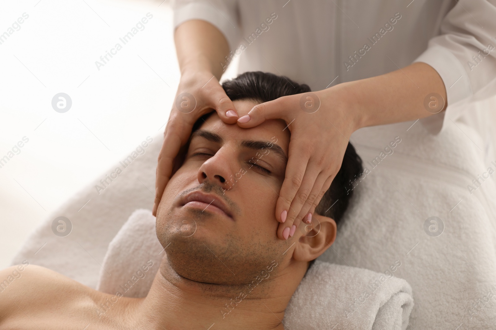 Photo of Man receiving facial massage in beauty salon