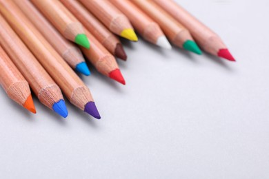 Photo of Colorful pastel pencils on white background, closeup with space for text. Drawing supplies