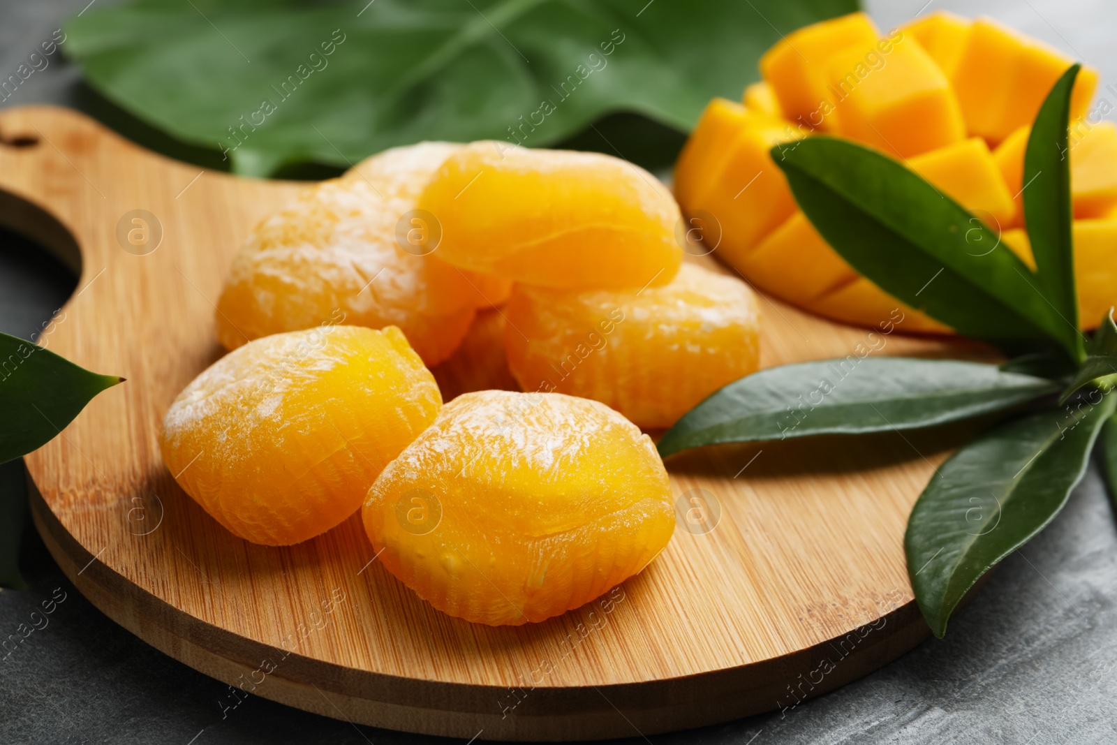 Photo of Delicious mango mochi on wooden board, closeup
