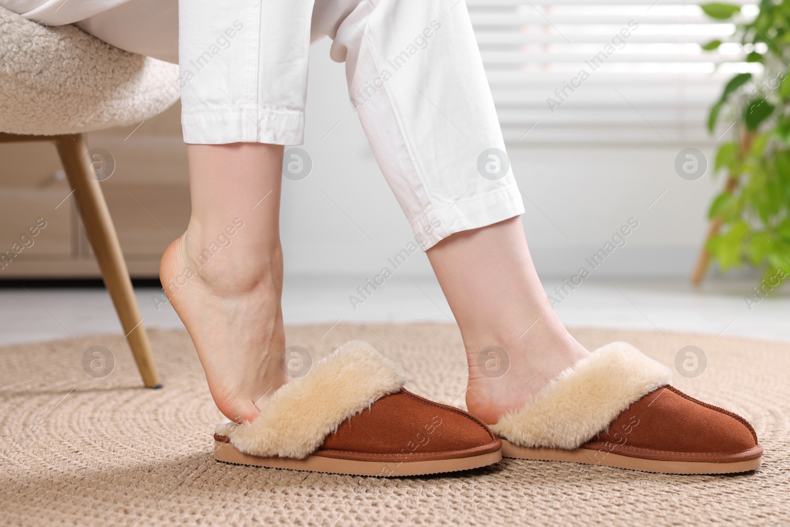 Photo of Woman in soft slippers at home, closeup