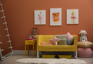 Photo of Cute pictures and comfortable sofa  in baby room interior