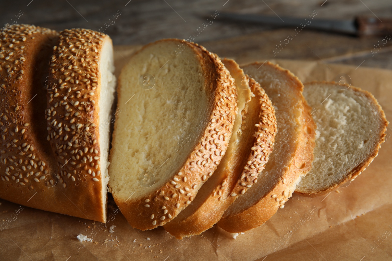 Photo of Tasty wheat bread on parchment paper, closeup