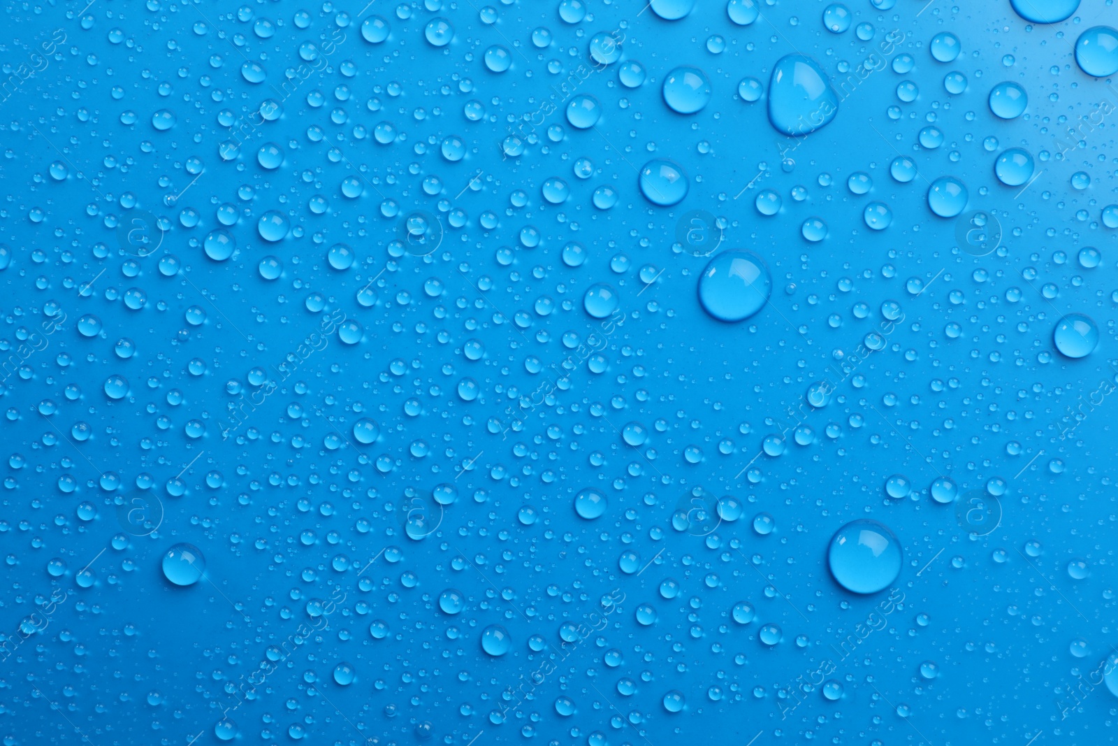 Photo of Water drops on light blue background, top view