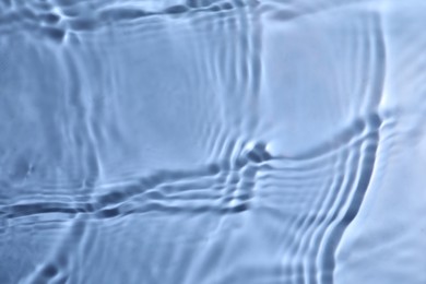 Photo of Closeup view of water with rippled surface on blue background