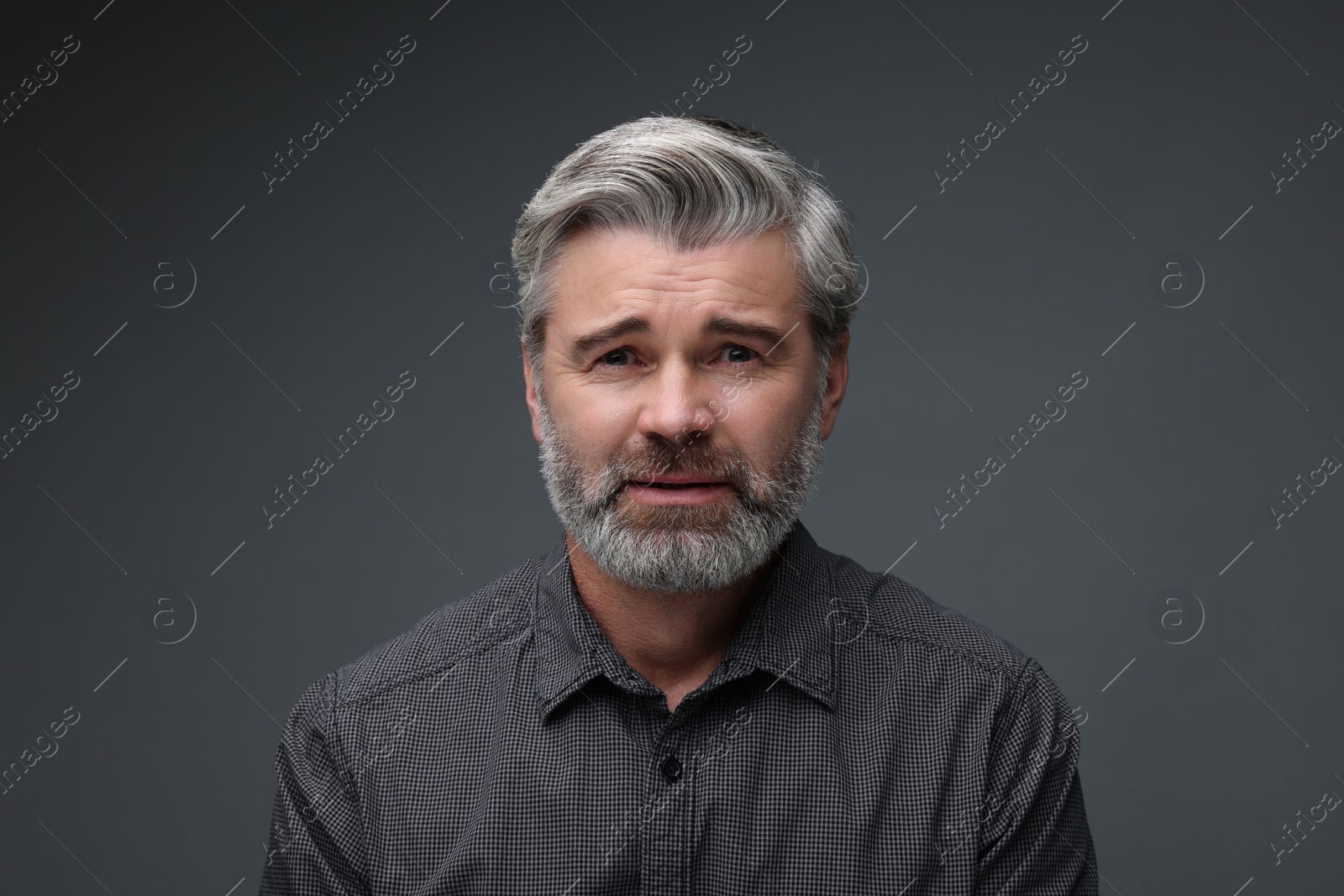 Photo of Personality concept. Portrait of sad man on dark grey background