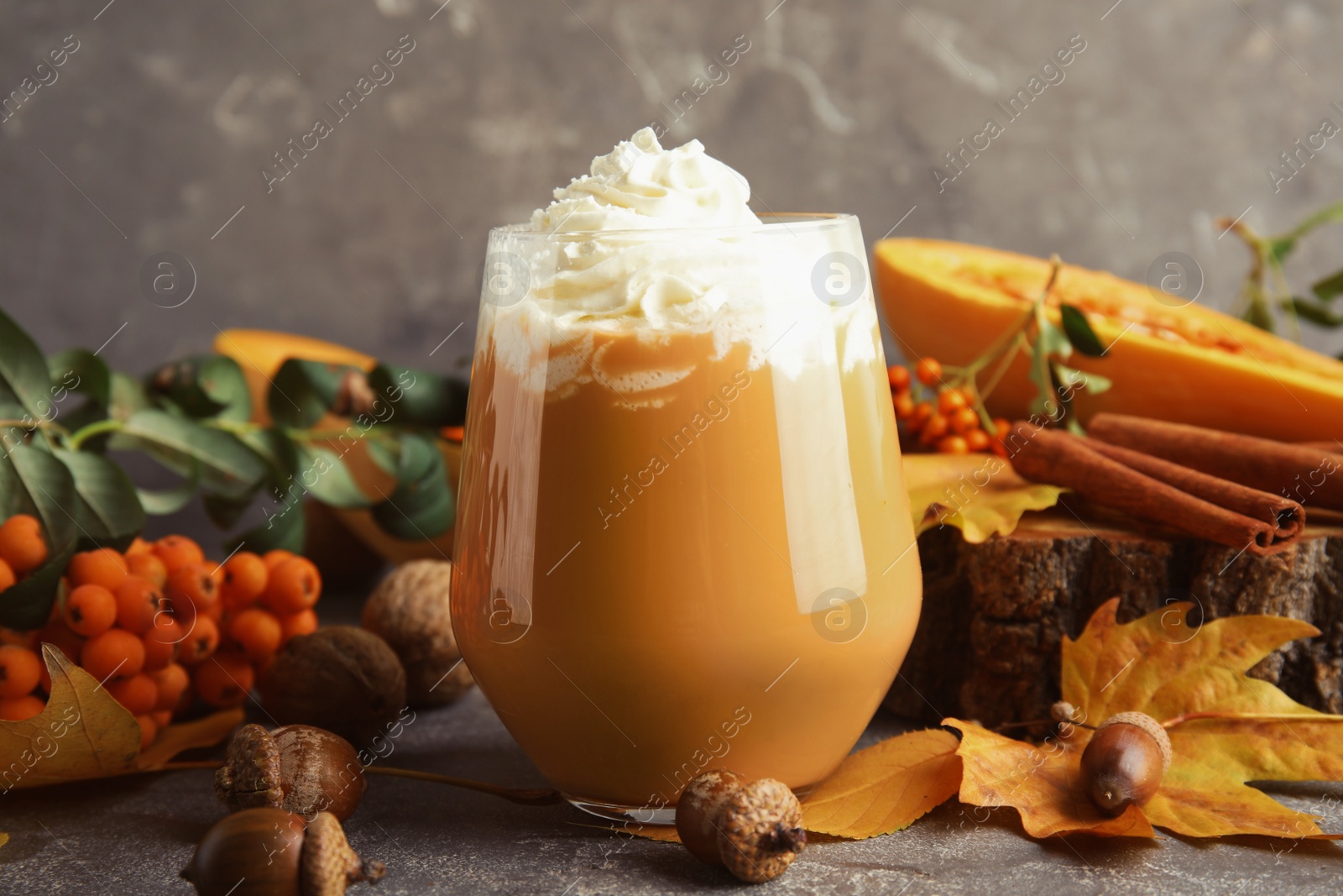 Photo of Composition with tasty pumpkin spice latte in glass on table