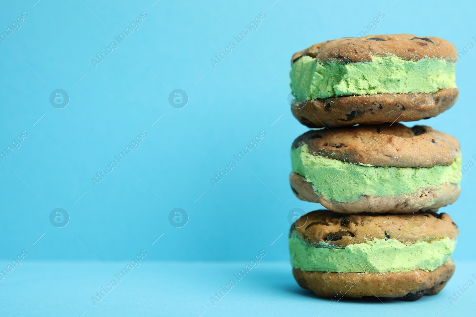 Photo of Sweet delicious ice cream cookie sandwiches on color background, space for text