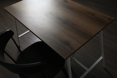 Photo of Modern empty wooden table and chair indoors, closeup