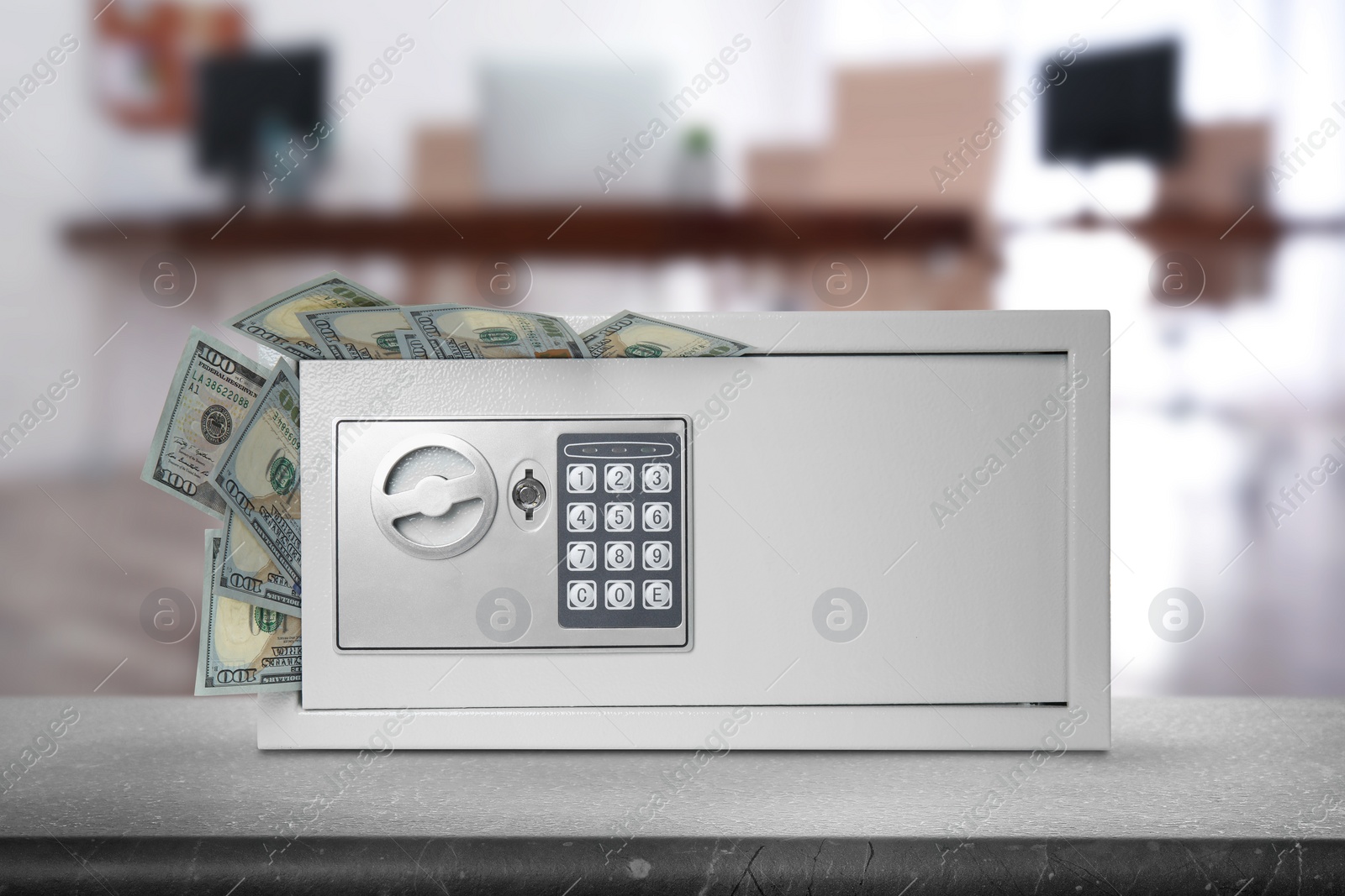 Image of Closed steel safe with electronic lock and money on light grey table indoors