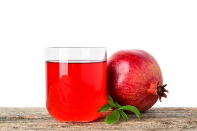 Photo of Refreshing pomegranate juice in glass, leaves and fruit on wooden table against white background