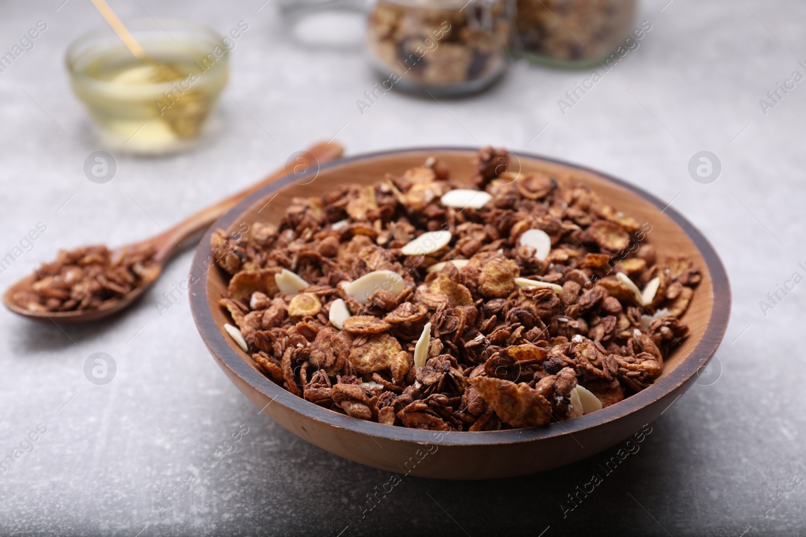 Photo of Tasty granola served with nuts and dry fruits on light grey table