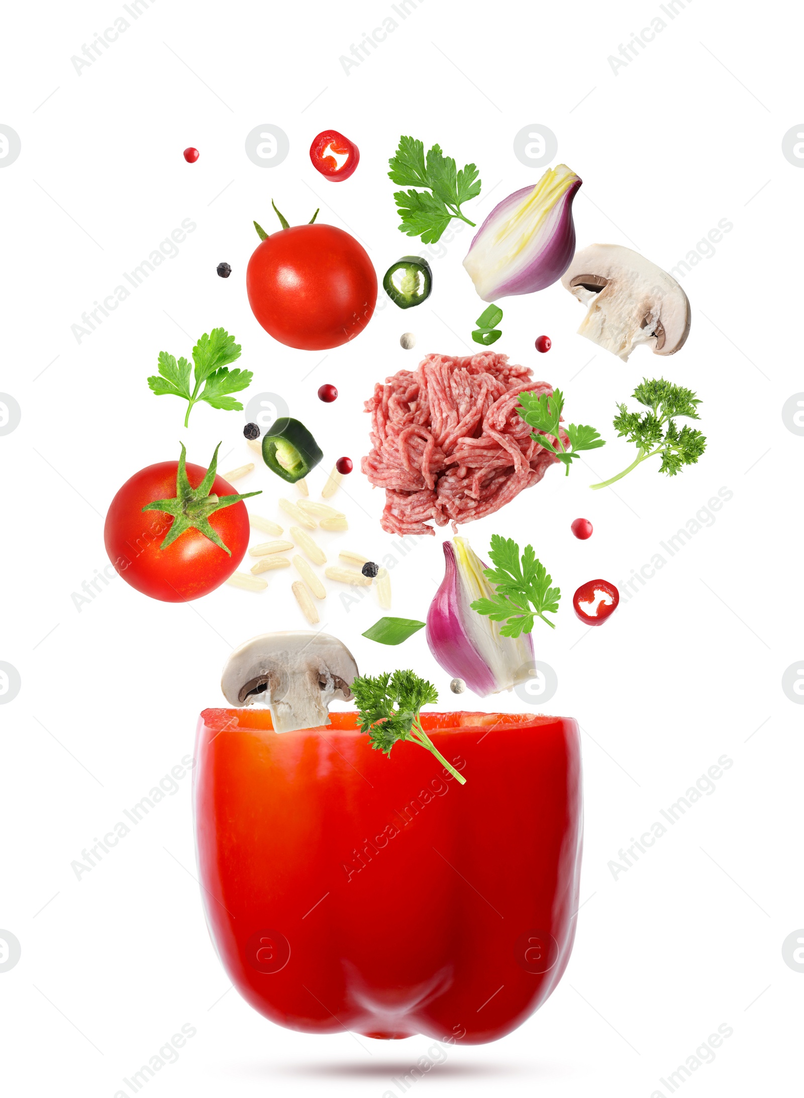 Image of Stuffed pepper recipe. Fresh ingredients falling into bell pepper on white background