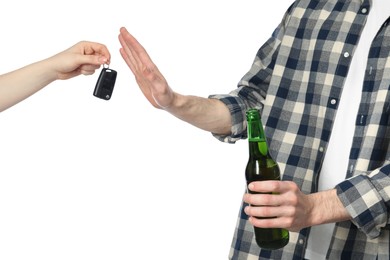 Photo of Man with bottle of beer refusing drive car while woman suggesting him keys on white background, closeup. Don't drink and drive concept