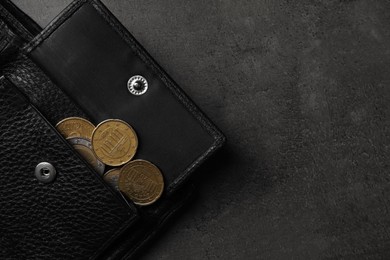 Poverty. Black wallet and coins on grey table, top view. Space for text