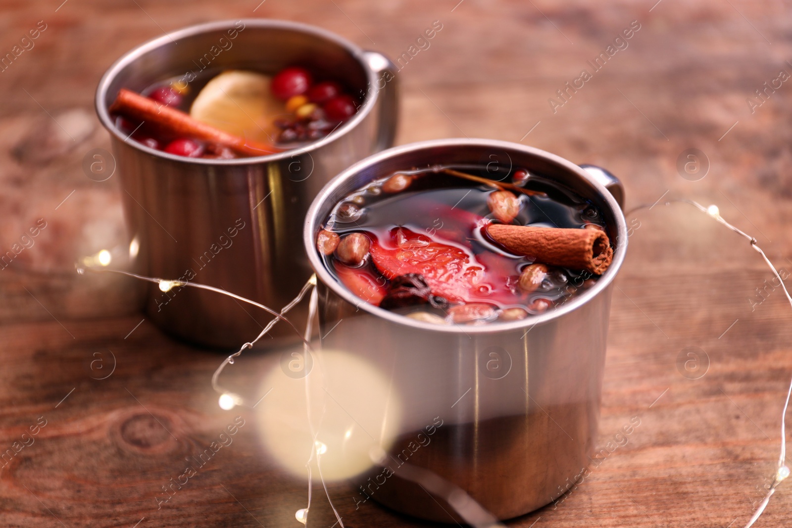 Photo of Tasty aromatic mulled wine on wooden table