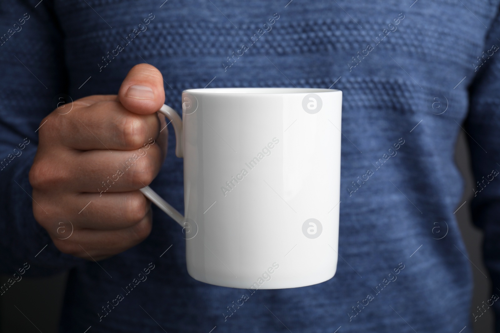 Photo of Man holding white mug, closeup. Mockup for design