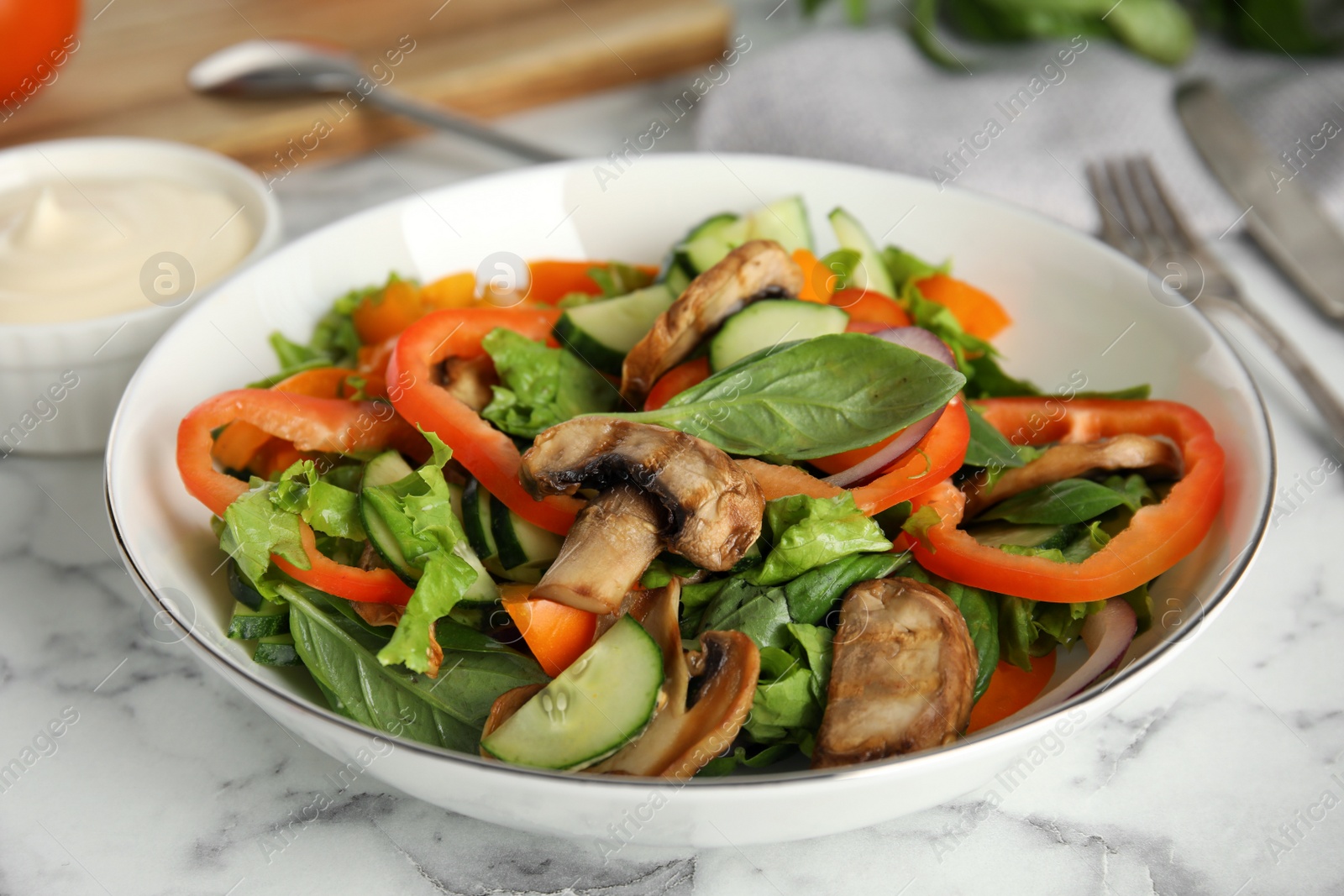 Photo of Bowl of delicious salad on white marble table, closeup