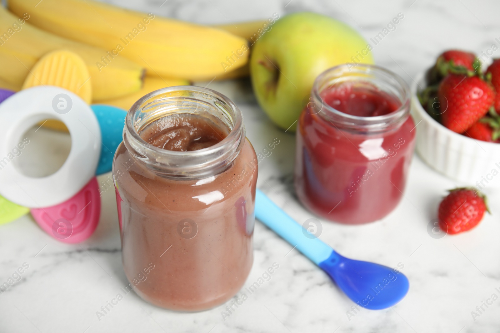 Photo of Healthy baby food in jars and fresh ingredients on white marble table